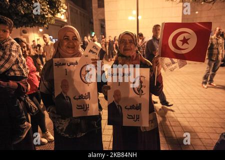 Frauen, die eine tunesische Flagge tragen, und Plakate mit dem Porträt von Kais Saied, während sie an einer Wahlkundgebung teilnehmen, die am 11. Oktober 2019 in der Avenue Habib Bourguiba in der Hauptstadt Tunis zur Unterstützung von Kais Saied, Der Professor für Verfassungsrecht und Präsidentschaftskandidat für die zweite Runde der tunesischen Präsidentschaftswahlen, vor dem Schweigen der Wahlen, das um Mitternacht beginnt. (Foto von Chedly Ben Ibrahim/NurPhoto) Stockfoto