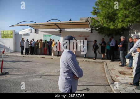 Eine Tunesierin steht am 13. Oktober in der Stadt Ennasr, im Gouvernement Ariana, nordöstlich von Tunesien, vor einem Wahllokal, um ihre Stimme für die Stichwahl abzugeben. 2019. (Foto von Chedly Ben Ibrahim/NurPhoto) Stockfoto
