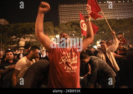 Der Unterstützer von Kais Saied hebt seine Arme und singt Slogans zur Unterstützung von Kais Saied, während die Tunesier am 13. Oktober 2019 in der Avenue Habib Bourguiba in der Hauptstadt Tunis den Sieg von Kais Saied bei den Präsidentschaftswahlen in Tunesien feiern. Die Flaggen Tunesiens werden gewellt. (Foto von Chedly Ben Ibrahim/NurPhoto) Stockfoto