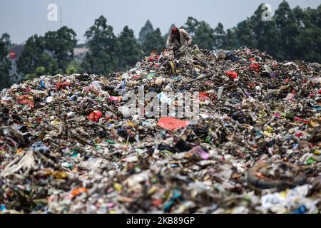 Am 14. Oktober 2019 sucht ein Mann auf der Mülldeponie Rawa Kucing in Tangerang, Provinz Banten, Indonesien, nach Artikeln und Kunststoffen, die er zum Recycling verkaufen kann. Hunderte von Indonesiern riskieren Krankheiten und andere Gefahren in ihrem Kampf um Gegenstände, die sie an Händler verkaufen können, von denen sie in der Region von 50.000 indonesischen Rupiah (USD3,53) verdienen können. Mehr als 1.400 Tonnen Abfall werden täglich an Tangerangs wichtigster Landfüllstelle deponiert. (Foto von Andrew Gal/NurPhoto) Stockfoto