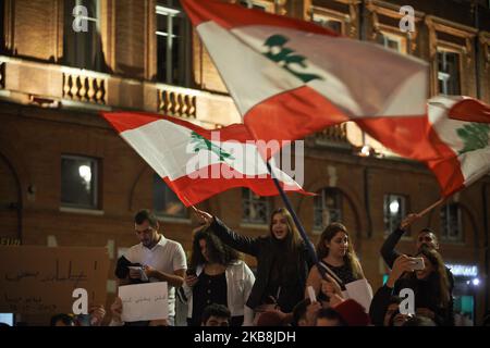 Die Menschen winken libanesische Flaggen. Die libanesische Gemeinschaft von Toulouse versammelte sich, um gegen ihre Regierung zu protestieren und die als korrupt gelten Eliten zu protestieren. Sie riefen dazu auf, dass Politiker wie Hariri, Präsident Michel Aoun und Parlamentspräsident Nabih Berri abtreten sollten.als der libanesische Premierminister Saad Hariri die Wirtschaftsreformen vorantreiben will und seine Unterstützung durch die Regierung fordert, fanden in Beirut 2. Tage lang Demonstrationen statt. Diese Demonstrationen wurden gewalttätig. Sie sind die größten Proteste des Libanon seit einem Jahrzehnt, die an die arabischen Revolten von 2011 erinnern. Toulouse. Frankreich. Oktober 18. 2019. (Foto von Alain Pitton/NurP Stockfoto