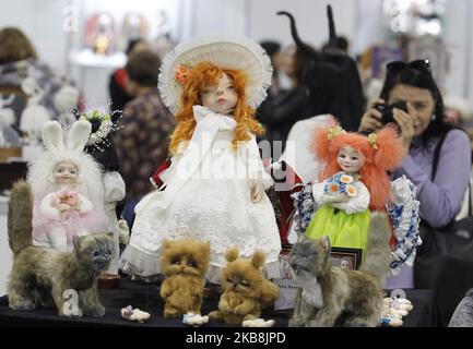 Ein Besucher macht ein Foto von Puppen während des XX Internationalen Salons von Author's Doll und Teddy 'Fashion Doll' ('Modna lyalka') in Kiew, Ukraine, am 18. Oktober 2019. Die jährliche internationale Schau der Autorenpuppe und des Teddys „Fashion Doll“ seit acht Jahren zieht die Aufmerksamkeit von Tausenden von Meistern, Künstlern, Sammlern und Liebhabern der Puppenkunst in der Ukraine und der weltweiten Kunstszene an. Ukrainische und ausländische Meister, Künstler, Kunstwerkstätten und Studios nehmen an der Show Teil und präsentieren den Besuchern eine großartige Ausstellung von Autorensammlungpuppen, OOAK-Puppen, antike Puppen, Innenpuppen, BJD Stockfoto