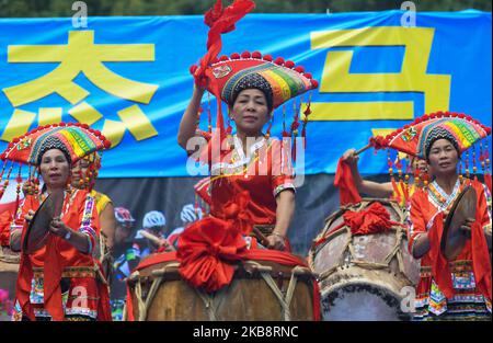 Mitglieder einer lokalen Musikband aus der ethnischen Gruppe von Zhuang, die in traditionellen Zhuang-Kleidern gekleidet ist, treten an der Ziellinie der vierten Etappe, Nanning bis Nongla Stage, der Ausgabe der Cycling Tour de Guangxi 3. 2019, auf. Am Sonntag, den 20. Oktober 2019, in der landschaftlich reizenden Region Nongla, Bezirk Mashan, Region Guangxi, China. (Foto von Artur Widak/NurPhoto) Stockfoto