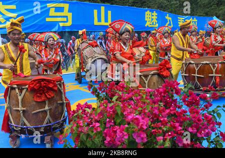 Mitglieder einer lokalen Musikband aus der ethnischen Gruppe von Zhuang, die in traditionellen Zhuang-Kleidern gekleidet ist, treten an der Ziellinie der vierten Etappe, Nanning bis Nongla Stage, der Ausgabe der Cycling Tour de Guangxi 3. 2019, auf. Am Sonntag, den 20. Oktober 2019, in der landschaftlich reizenden Region Nongla, Bezirk Mashan, Region Guangxi, China. (Foto von Artur Widak/NurPhoto) Stockfoto