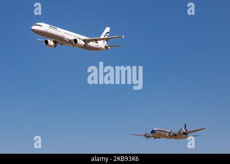 Schnappschüsse während der Flugwoche Athen AFW 2019. Ein Aegean Airbus A321 mit der Registrierung SX-DGA und ein historischer, alt renovierter Douglas DC-6B von Red Bull ( Flying Bulls Team ), der 1958 gebaut wurde und mit der Registrierung OE-LDM nebeneinander in einer Formation vor den Zuschauern fliegt, Am 2019 22. September 2019 über die Startbahn auf der Flugschau der Flugwoche 8. in Athen auf dem LGTG-Flughafen der Tanagra Military Air Base in Griechenland. (Foto von Nicolas Economou/NurPhoto) Stockfoto