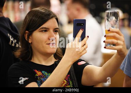 Eine Besucherin fotografiert ihr Bier während des Warsaw Beer Festival in Warschau, Polen, am 25. Oktober 2019. Das Warschauer Bierfestival 11. präsentiert den Besuchern über 800 Biere vom Fass und mehr als hundert Premieren von Bieren, die nicht in den Geschäften erhältlich sind. Polen hat seit einigen Jahren einen großen Anstieg an lokal gebrauten und spezialgebrauten Bieren erlebt. (Foto von Jaap Arriens/NurPhoto) Stockfoto