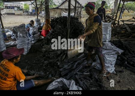 Handwerker von Generation zu Generation verarbeiten Mangrovenholz in der dapur arang Heimindustrie manuell zu Holzkohle. In Kampung Tua Tanjung Gundap, Batam, kepulauan Riau Indonesia, am 5. August 2019. Die Anzahl der Mangrovenwälder, die entlang der Küste von Batam gedeihen, ist ein Segen. Abgesehen davon, dass sie als traditionelle Fischer arbeiten, schneiden einige Bewohner Mangroven ab und verarbeiten das Holz zu Holzkohle. Die verarbeitete Holzkohle der Bewohner von Batam ist von hohem wirtschaftlichen Wert und in Singapur sehr verkaufsfähig. So wird Kohle zu einem der meistverkauften Rohstoffe, die in Singapur gehandelt werden. Kohle ist ein Brennstoff Stockfoto