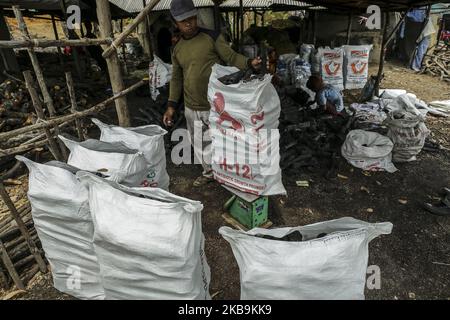 Handwerker von Generation zu Generation verarbeiten Mangrovenholz in der dapur arang Heimindustrie manuell zu Holzkohle. In Kampung Tua Tanjung Gundap, Batam, kepulauan Riau Indonesia, am 5. August 2019. Die Anzahl der Mangrovenwälder, die entlang der Küste von Batam gedeihen, ist ein Segen. Abgesehen davon, dass sie als traditionelle Fischer arbeiten, schneiden einige Bewohner Mangroven ab und verarbeiten das Holz zu Holzkohle. Die verarbeitete Holzkohle der Bewohner von Batam ist von hohem wirtschaftlichen Wert und in Singapur sehr verkaufsfähig. So wird Kohle zu einem der meistverkauften Rohstoffe, die in Singapur gehandelt werden. Kohle ist ein Brennstoff Stockfoto