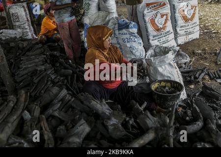 Handwerker von Generation zu Generation verarbeiten Mangrovenholz in der dapur arang Heimindustrie manuell zu Holzkohle. In Kampung Tua Tanjung Gundap, Batam, kepulauan Riau Indonesia, am 5. August 2019. Die Anzahl der Mangrovenwälder, die entlang der Küste von Batam gedeihen, ist ein Segen. Abgesehen davon, dass sie als traditionelle Fischer arbeiten, schneiden einige Bewohner Mangroven ab und verarbeiten das Holz zu Holzkohle. Die verarbeitete Holzkohle der Bewohner von Batam ist von hohem wirtschaftlichen Wert und in Singapur sehr verkaufsfähig. So wird Kohle zu einem der meistverkauften Rohstoffe, die in Singapur gehandelt werden. Kohle ist ein Brennstoff Stockfoto