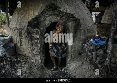 Handwerker von Generation zu Generation verarbeiten Mangrovenholz in der dapur arang Heimindustrie manuell zu Holzkohle. In Kampung Tua Tanjung Gundap, Batam, kepulauan Riau Indonesia, am 5. August 2019. Die Anzahl der Mangrovenwälder, die entlang der Küste von Batam gedeihen, ist ein Segen. Abgesehen davon, dass sie als traditionelle Fischer arbeiten, schneiden einige Bewohner Mangroven ab und verarbeiten das Holz zu Holzkohle. Die verarbeitete Holzkohle der Bewohner von Batam ist von hohem wirtschaftlichen Wert und in Singapur sehr verkaufsfähig. So wird Kohle zu einem der meistverkauften Rohstoffe, die in Singapur gehandelt werden. Kohle ist ein Brennstoff Stockfoto