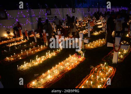 Katholiken aus Bangladesch beten am 02. November 2019 auf einem Friedhof in Dhaka, Bangladesch, nach dem Anzünden von Kerzen für ihre verstorbenen Verwandten. Christliche Gläubige beobachten den Tag aller Seelen, bekannt als das Fest aller Seelen, Gedenken an alle verstorbenen Gläubigen. An diesem Tag kommen Christen auf den Friedhof und beten für die verstorbenen Seelen ihrer Angehörigen. All Soul's Day ist ein römisch-katholischer Gedenktag für verstorben Freunde und Verwandte. Dies kommt vom alten Pagan Festival of the Dead, das den heidnischen Glauben feierte, dass die Seelen der Toten für ein Essen zurückkehren würden Stockfoto