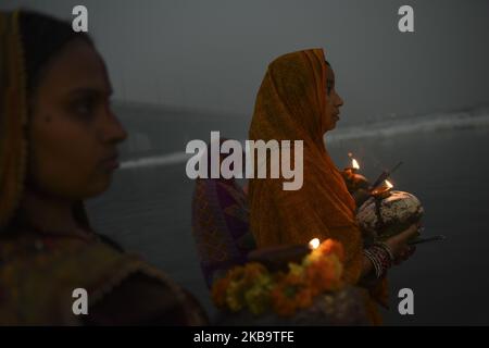 Indische Anhänger führen während des Sonnenaufgangs im verschmutzten Yamuna-Fluss, der mit giftigem Schaum bedeckt ist, der durch Industrieabfälle verursacht wird, während des Chhath Puja Festivals in Neu Delhi, Indien, 03. November 2019 Rituale durch. (Foto von Indraneel Chowdhury/NurPhoto) Stockfoto