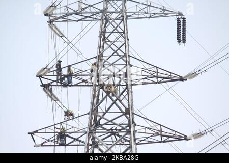 Am Dienstag, den 5. November 2019, bauen Arbeiter im 35.000-Megawatt-Stromprojekt in Jakarta elektrische Anlagen in Hochspannungstürmen auf. Das Abrutschen der wirtschaftlichen und Investitionsziele Indonesiens hat Präsident Joko widodo zu seinem ehrgeizigen Projekt Fahren Sie langsamer. gemacht Das Megaprojekt, das 2015 ins Leben gerufen wurde und in 5 Jahren abgeschlossen werden soll, realisiert derzeit nur 3.600 Megawatt, was die Regierung dazu führt, dass die Fertigstellung des Projekts im Jahr 2022-2023 verschoben werden muss (Foto: Aditya Irawan/NurPhoto) Stockfoto