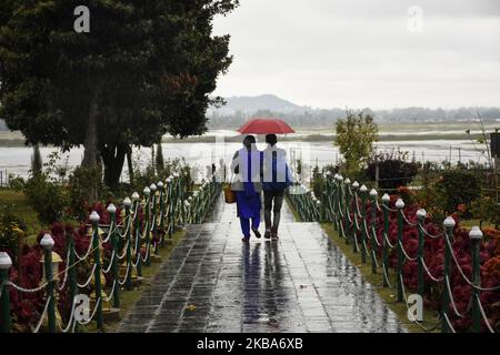 Ein Paar geht inmitten von Niederschlägen, als der Herbst am 06. November 2019 in Srinagar, dem von Indien verwalteten Kaschmir, eintrifft. (Foto von Muzamil Mattoo/NurPhoto) Stockfoto