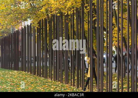 Ein Besucher macht ein Foto in der Nähe einer Linie von Metallmasten, die zeigen, wo die Berliner Mauer einst in der Bernauer Straße stand, gesehen am Vorabend des bevorstehenden 30.. Jahrestages des Falls der Berliner Mauer. Deutschland feiert diese Woche drei Jahrzehnte seit dem Fall der Berliner Mauer mit den Hauptfeiern in der deutschen Hauptstadt am Samstag, dem 9. November 2019. Am Freitag, den 8. November 2019, in Berlin, Deutschland. (Foto von Artur Widak/NurPhoto) Stockfoto