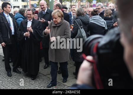 Bundeskanzlerin Angela Merkel (Mitte) und Markus Droege (links), Bischof der Evangelischen Kirche Berlin-Brandenburg-Schlesischen Oberlausitz, kommen mit Kerzen an die Gedenkstätte Berliner Mauer in der Bernauer Straße, um sie anlässlich der Gedenkfeier zum 30.. Jahrestag des Mauerfalls zu platzieren. Am Samstag, den 9. November 2019, in Berlin, Deutschland. (Foto von Artur Widak/NurPhoto) Stockfoto