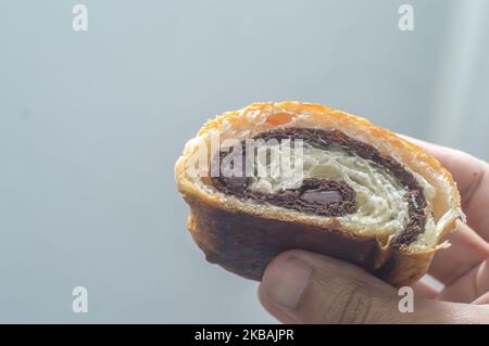 Pain au Chocolat halbieren und innen mit natürlichem, hellem „Schokoladenbrot“ mit foled-Teig zeigen. Stockfoto