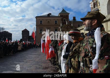 Menschen mit polnischen Nationalflaggen in historischen polnischen Militäruniformen vor dem Schloss Wawel vor den offiziellen Feierlichkeiten zum 11.. November – dem polnischen Unabhängigkeitstag und zum 101.. Jahrestag der Wiederherstellung der Souveränität Polens als zweite polnische Republik im Jahr 1918. Am 11. November 1918 erlangte Polen nach 123 Jahren Gefangenschaft seine Unabhängigkeit zurück, während derer Polen unter der Herrschaft von drei Teilstaaten stand: Österreich, Preußen und Russland. (Foto von Artur Widak/NurPhoto) Stockfoto