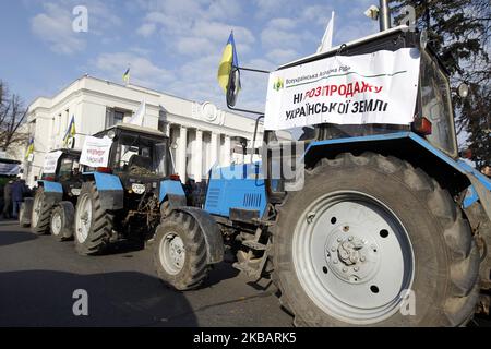 Bauerntraktoren mit Plakaten mit der Aufschrift „Nein zum Verkauf von ukrainischem Land!“ Werden während zwei Kundgebungen gesehen - zur Unterstützung und gegen die Landreform, in der Nähe des ukrainischen Parlaments in Kiew, Ukraine, am 12. November 2019. (Foto von STR/NurPhoto) Stockfoto