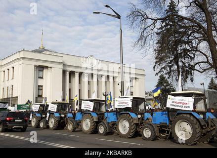 Bauerntraktoren mit Plakaten mit der Aufschrift „Nein zum Verkauf von ukrainischem Land!“ Werden während zwei Kundgebungen gesehen - zur Unterstützung und gegen die Landreform, in der Nähe des ukrainischen Parlaments in Kiew, Ukraine, am 12. November 2019. (Foto von STR/NurPhoto) Stockfoto