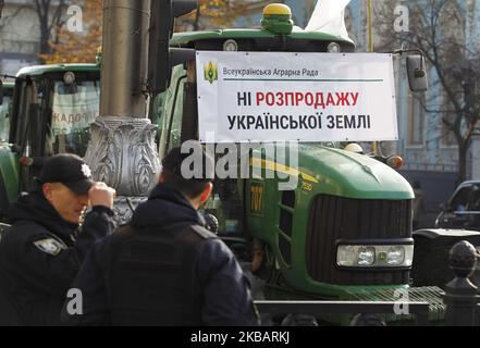 Bauerntraktoren mit Plakaten mit der Aufschrift „Nein zum Verkauf von ukrainischem Land!“ Werden während zwei Kundgebungen gesehen - zur Unterstützung und gegen die Landreform, in der Nähe des ukrainischen Parlaments in Kiew, Ukraine, am 12. November 2019. (Foto von STR/NurPhoto) Stockfoto