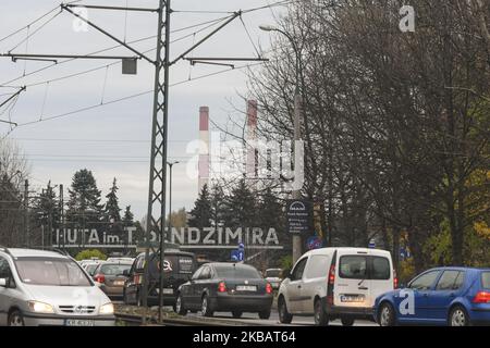 Ein Blick auf das Schild 'T. Sendzimir Steelworks' (Polnisch: Huta im. T. Sendzimira) und Schornsteinen in Nowa Huta, mit einem geschäftigen Verkehr auf der Solidarity Avenue. ArcelorMittal Polen hat heute aufgrund der schwächeren Marktprognosen eine vorübergehende Einstellung seines Hochofen- und Stahlwerks in Krakau-Nowa Huta am 23. November angekündigt. Am Dienstag, den 12. November 2019, Polen. (Foto von Artur Widak/NurPhoto) Stockfoto