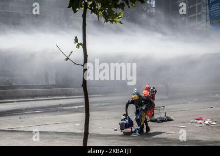 Santiago, Chile. 11. November 2019. Ein Straßenhändler startet das Auto wirft Wasser. In Städten im ganzen Land organisierten die Chilenen einen Generalstreik, um die Freiheit der öffentlichen Bildung, Verbesserungen des Gesundheitssystems und Reformen des Rentensystems in Santiago, Chile, zu fordern. (Foto von Fernando Lavoz/NurPhoto) Stockfoto