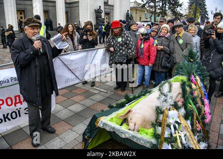 Der Mann ist ähnlich wie Lenin haben Rede in der Nähe von Dead Schwein in einem Sarg symbolisch für die Tierhaltung Beerdigung, während der Demonstration. Ukrainische Bauern protestieren vor dem ukrainischen Parlament (Verkhovna Rada) gegen die Öffnung eines Landmarktes und den Verkauf von Land in der Ukraine. Kiew, Ukraine. 13-11-2019 (Foto von Maxym Marusenko/NurPhoto) Stockfoto