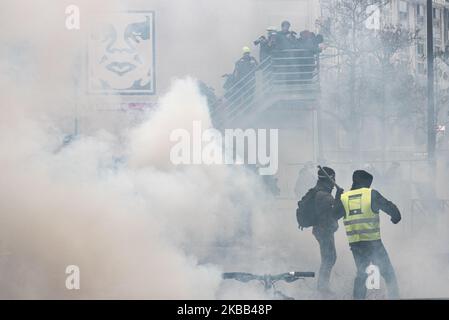 Demonstranten aus dem Schwarzen Block, schwarz gekleidet und mit Kapuze, Und die Gelben Westen starten Stöcke und Kopfsteinpflaster auf die Polizei unter den Augen der Fotografen und Kameramann auf dem Place d'Italie, an diesem Samstag, dem 16. November 2019, während in Paris die Jubiläumsveranstaltung der Gelben Westen zum 1. Jahr der Bewegung stattfand. Eine große Demonstration sollte zwischen dem Place d'Italie und dem Gare du Nord stattfinden, aber nach Szenen der Gewalt zwischen dem Schwarzen Block und der Polizei, hat die Präfektur den marsch abgesagt, der Szenen des Chaos Platz machte. (Foto von Samuel Boivin/NurPhoto) Stockfoto