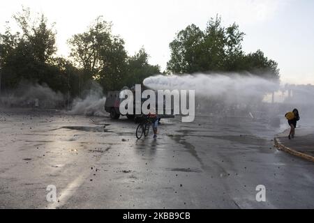 Ein regierungsfeindlicher Demonstrator fordert bei Zusammenstößen mit der Polizei in Santiago, Chile, am Donnerstag, 30. Oktober 2019, einen Wasserkanonenstrahl der Polizei heraus. (Foto von Jeremias Gonzalez/NurPhoto) Stockfoto