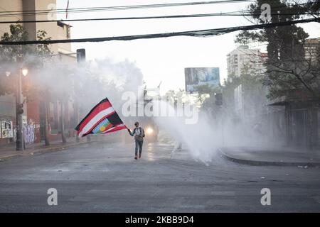 Ein regierungsfeindlicher Demonstrator fordert bei Zusammenstößen mit der Polizei in Santiago, Chile, am Donnerstag, 30. Oktober 2019, einen Wasserkanonenstrahl der Polizei heraus. (Foto von Jeremias Gonzalez/NurPhoto) Stockfoto