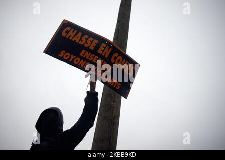 Ein schwarz gekleideter Protestler hält ein Plakat mit der Aufschrift „Jagd in Arbeit, gemeinsam wachsam sein“. Die Demonstranten der Gelbwesten demonstrierten die 53. Wochen in Folge zum ersten Jahrestag der Bewegung „Gelbwesten“ (Gilets Jaunes). Sie planen an diesem Wochenende eine Reihe landesweiter Demonstrationen, um der Regierung zu zeigen, dass sie am ersten Jahrestag ihrer Bewegung noch Unterstützung finden kann. Mehrere tausend Demonstranten gingen auf die Straßen von Toulouse. Doch der friedliche Protest kam zu einem plötzlichen Ende, als Bereitschaftspolizei und Gendarmerie Mobile (Militär) Wasserwerfer und Wühlmaus abfeuerten Stockfoto