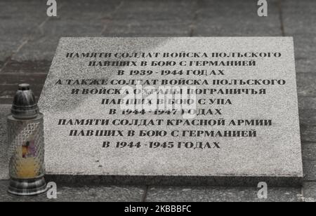 Eine Gedenktafel auf Russisch: "Zum Gedenken an polnische Soldaten, die in den Jahren 1939 bis 1944 in Schlachten mit Deutschen starben, und polnische Soldaten und Grenzschutzkräfte, die im Kampf mit der UPA in den Jahren 1944 bis 1947 ums Leben kamen. Zum Gedenken an die russischen Soldaten, die in den Kämpfen mit den Deutschen in 1944-1945' umgekommen sind. Die Gedenkstätte enthält die Überreste von 5.127 polnischen und sowjetischen Soldaten, die im Jahr 1944 im Kampf gegen die Deutschen in den umliegenden Gebieten gefallen sind, und polnischen Soldaten, die im Jahr 1945-47 im Kampf gegen die UPA (Ukrainische Aufständische Armee) gefallen sind. Am Sonntag, 17. November 2019, in Ustrzyki Dolne, Woiwodschaft Podkarpackie, Stockfoto