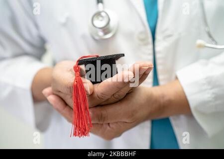 Asiatische Arzt Studie lernen mit Abschluss GAP Hut in Krankenhausstation, clever hell Genie Bildung Medizin Konzept. Stockfoto
