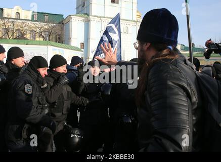 Ein Mann, der als Priester gekleidet ist, steht in Konflikt mit der Polizei, als er versuchte, gegen die Kundgebung von Transgender in Kiew, Ukraine, am 23. November 2019 zu protestieren. Dutzende von Menschen nehmen an der Kundgebung zum Internationalen Tag des Gedenkens an Transgender-Menschen, die durch Transphobie getötet wurden, 20. Teil. (Foto von Sergii Chartschenko/NurPhoto) Stockfoto