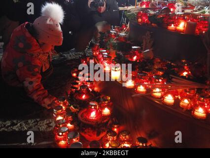 Ein Kind stellt am 23. November 2019 eine Kerze an ein Denkmal für die Opfer des Holodomors in Kiew, Ukraine,. Die Ukrainer begehen den Jahrestag der Großen Hungersnot in der sowjetischen Ukraine 1932-33, die viele als einen Völkermord betrachten, der vom damaligen sowjetischen Führer Joseph Stalin angeordnet wurde, wo Millionen Ukrainer in einer Hungerkatastrophe starben, wie sie in der Geschichte der Ukraine noch nie zuvor war. (Foto von STR/NurPhoto) Stockfoto