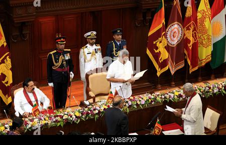 Der ehemalige parlamentspräsident Sri Lankas und ältere Bruder des Präsidenten, Chamal Rajapaksa (R), schwört als Verteidigungsminister des Staates, während Präsident Gotabaya Rajapaksa seine Akten durchgeht, während ihr Bruder, premierminister Mahinda Rajapaksa (L) blickt während der Vereidigung auf Ministerebene im Präsidialsekretariat in Colombo, Sri Lanka, darauf. Mittwoch, 27. November 2019 (Foto von Tharaka Basnayaka/NurPhoto) Stockfoto