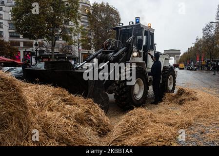 Rund hundert Bauern gossen Stroh auf die Champs-Elysées, bevor sie am Mittwoch, den 27. November 2019, von der Polizei umzingelt wurden. Auf Initiative der Landwirtschaftsgewerkschaften FNSEA und der Jeunes Agriculteurs (ja) übernahmen etwa tausend Traktoren und Bauern die Pariser Ringstraße und organisierten eine Verkehrsblockade, um gegen die Anti-Pestizid-Befehle und das, was sie Agribashing nennen, zu protestieren. Sie besetzten die Peripherie und kurz die Champs-Elysées, während sie darauf warteten, vom zuständigen Minister und einem Vertreter des Elysée empfangen zu werden. (Foto von Samuel Boivin/NurPhoto) Stockfoto