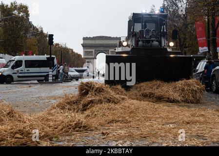 Rund hundert Bauern gossen Stroh auf die Champs-Elysées, bevor sie am Mittwoch, den 27. November 2019, von der Polizei umzingelt wurden. Auf Initiative der Landwirtschaftsgewerkschaften FNSEA und der Jeunes Agriculteurs (ja) übernahmen etwa tausend Traktoren und Bauern die Pariser Ringstraße und organisierten eine Verkehrsblockade, um gegen die Anti-Pestizid-Befehle und das, was sie Agribashing nennen, zu protestieren. Sie besetzten die Peripherie und kurz die Champs-Elysées, während sie darauf warteten, vom zuständigen Minister und einem Vertreter des Elysée empfangen zu werden. (Foto von Samuel Boivin/NurPhoto) Stockfoto