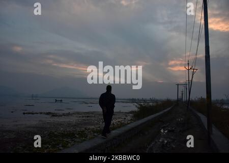 Ein Mann geht am 29. November 2019 am Ufer des Dal Lake, Srinagar, dem von Indien verwalteten Kaschmir, spazieren. (Foto von Muzamil Mattoo/NurPhoto) Stockfoto