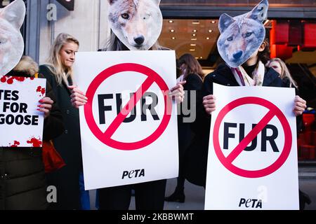 Tierrechtler, die PETA-Plakate halten, demonstrieren am 29. November 2019 gegen die Verwendung von echtem Fell durch den Bekleidungshändler Canada Goose vor dem Geschäft des Unternehmens in der Regent Street in London, England. (Foto von David Cliff/NurPhoto) Stockfoto