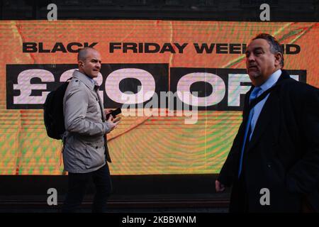 Am 29. November 2019 laufen die Menschen an einem Schild vorbei, auf dem die Rabatte für den Black Friday in einem Geschäft in der Regent Street St James's in London, England, angezeigt werden. (Foto von David Cliff/NurPhoto) Stockfoto