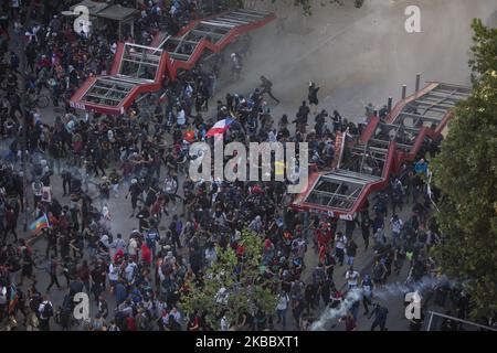 Regierungsfeindliche Demonstranten versammeln sich unter Tränengas, das von Bereitschaftspolizisten während eines Protestes in Santiago, Chile, 01. November 2019 gestartet wurde (Foto: Jeremias Gonzalez/NurPhoto) Stockfoto