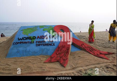 Eine Awareness-Sandskulptur ist am östlichen Küstenstrand der Bucht von Bengalen zu sehen, wie sie vom Sandkünstler Manas Sahoo für Besucher geschaffen wird, die sich über den Welt-Aids-Tag informieren, der 65 km von der ostindischen Hauptstadt Bhubaneswar des Staates Odisha entfernt ist. (Foto von STR/NurPhoto) Stockfoto