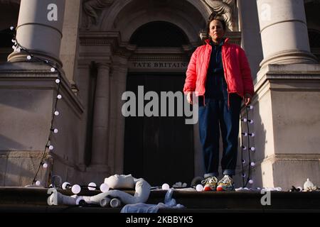 Die Künstlerin Anne Hardy posiert mit ihrer Licht- und Klanginstallation 'The Depth of Darkness The Return of the Light' am 30. November 2019 auf den Stufen der Tate Britain Kunstgalerie in London, England. Hardys Werk, das heute als Winterkommission der Galerie 2019 vorgestellt wurde, soll das Gebäude wie einen 'befestigten Tempel' wirken lassen. Ein donnernder Soundtrack begleitet die physischen Objekte, die an den Stufen und dem Mauerwerk der Fassade der Galerie befestigt sind. Die Installation wird bis zum 26. Januar nächsten Jahres in Kraft bleiben. (Foto von David Cliff/NurPhoto) Stockfoto