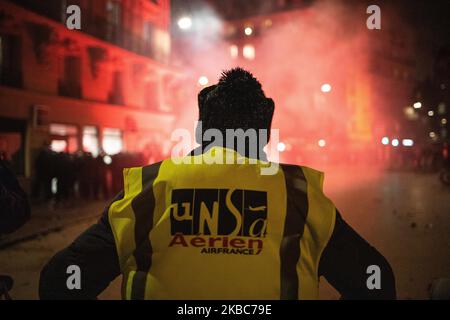 Eine Gilet Jaune oder Gelbwesten sieht Tränengas aus, als Demonstranten und die französische Polizei bei einer Kundgebung nahe dem Place de Republique zur Unterstützung des nationalen Streiks in Frankreich, einem der größten landesweiten Streiks seit Jahren, am 05. Dezember 2019 in Paris, Frankreich, zusammenprallen. (Foto von Jerome Gilles/NurPhoto) Stockfoto