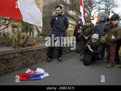 Während einer Kundgebung von belarussischen Bürgern und ukrainischen Aktivisten, die sie unterstützen, gegen die Integration von Belarus mit Russland, in der Nähe der Botschaft von Belarus in Kiew, Ukraine, am 07. Dezember 2019, brannte ein Protestor die russische Flagge. Der russische Präsident Wladimir Putin und der weißrussische Präsident Alexander Lukaschenko diskutieren laut Medienberichten bei einem Treffen in Sotschi am 7. Dezember 2019 über Integration und Gas. (Foto von STR/NurPhoto) Stockfoto