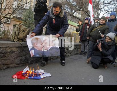 Während einer Kundgebung von belarussischen Bürgern und ukrainischen Aktivisten, die sie unterstützen, gegen die Integration von Belarus mit Russland, in der Nähe der Botschaft von Belarus in Kiew, Ukraine, am 07. Dezember 2019, brannte ein Protestor die russische Flagge. Der russische Präsident Wladimir Putin und der weißrussische Präsident Alexander Lukaschenko diskutieren laut Medienberichten bei einem Treffen in Sotschi am 7. Dezember 2019 über Integration und Gas. (Foto von STR/NurPhoto) Stockfoto