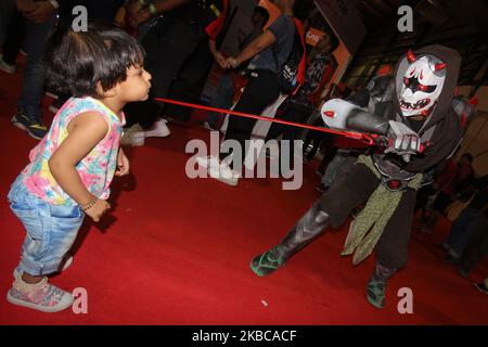 Ein in Kostüm gekleideter Mann spielt mit einem Kind während der Ausgabe der ‘„Comic Con“ 9. in Mumbai, Indien, am 07. Dezember 2019. (Foto von Himanshu Bhatt/NurPhoto) Stockfoto