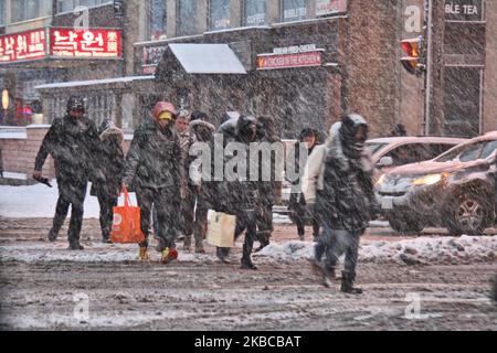 Die Menschen überqueren die Straße, als am 06. Dezember 2019 ein massiver Schneesturm in Toronto, Ontario, Kanada, eintraf. Der Sturm ließ 10 Zentimeter Schnee über den Großraum Toronto fallen und verursachte zahlreiche Fahrzeugunfälle in der Stadt während des morgendlichen Pendelfluges. (Foto von Creative Touch Imaging Ltd./NurPhoto) Stockfoto